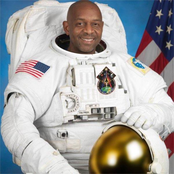 一个穿着宇航员制服的人对着镜头微笑.